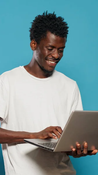 Africano americano hombre usando portátil para el entretenimiento —  Fotos de Stock