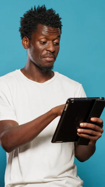 Hombre afroamericano usando tableta digital y sonriendo —  Fotos de Stock