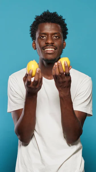 Sağlıklı vejetaryen diyeti için limon tutan neşeli insan. — Stok fotoğraf