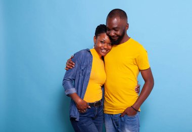 Gülümseyen çift kucaklaşır ve arka planda durur.