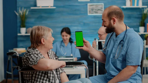 Homme infirmière tenant écran vert sur smartphone — Photo