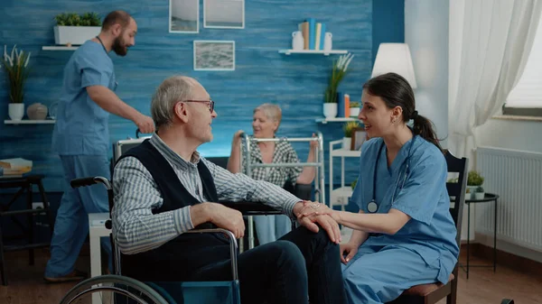 Медсестра надає допомогу пенсіонеру з інвалідністю — стокове фото