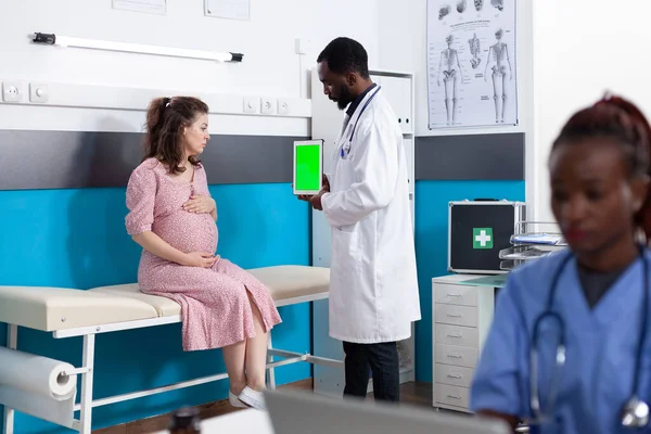 Tablette dikey yeşil ekrana bakan hamile bir kadın. — Stok fotoğraf
