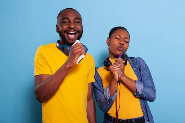 Szczęśliwa para za pomocą smartfona jako mikrofonu do śpiewania piosenki — Zdjęcie stockowe