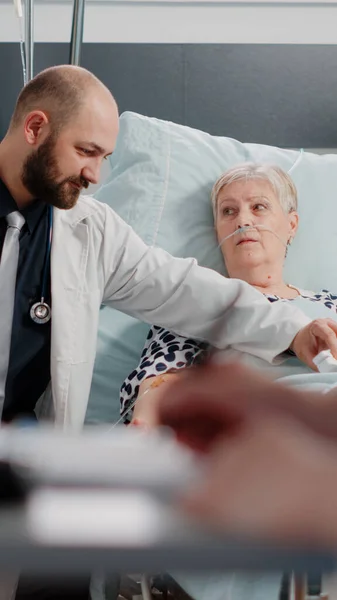 Dokter in gesprek met gepensioneerde vrouw met ziekte op ziekenhuisafdeling — Stockfoto