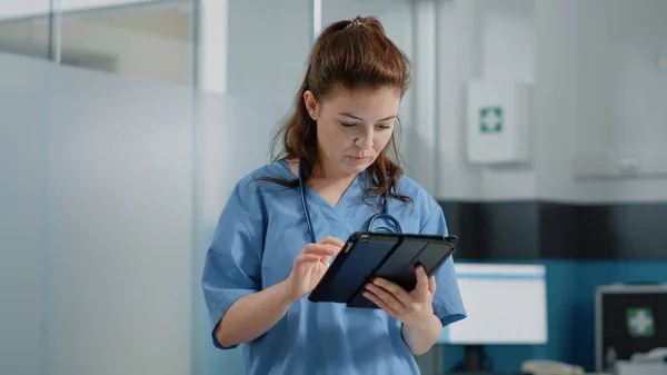 Kaukasische Krankenschwester mit digitalem Tablet mit Touchscreen — Stockfoto