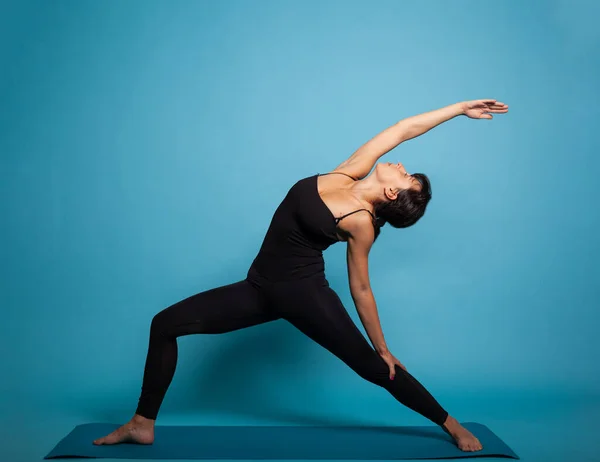 Allenatore donna in piedi su tappetino yoga praticare esercizi di fitness — Foto Stock