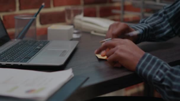 Ділова людина кладе клей, розміщуючи папір на дисплеї ноутбука — стокове відео
