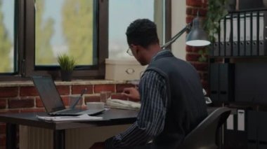 Ofis çalışanı iş görüşmesine cevap vermek için sabit telefonu kullanıyor.