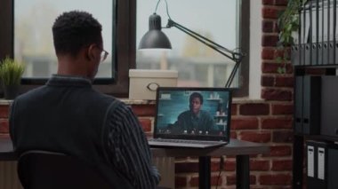 Başlangıç çalışanı iş arkadaşıyla konuşmak için bilgisayardaki video çağrısını kullanıyor