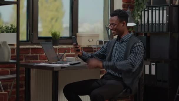 Kantoormedewerker die smartphone gebruikt om te praten op videogesprek op het werk — Stockvideo