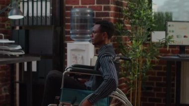 Tekerlekli sandalyedeki Afrikalı Amerikalı adam dizüstü bilgisayarda satış artışı planlıyor