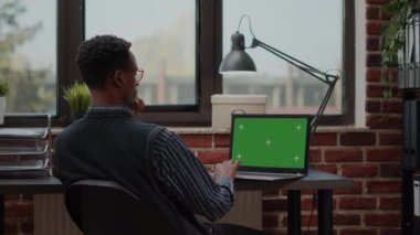 İşadamı dizüstü bilgisayarla çalışıyor ve ekranda yeşil ekran