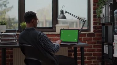 Erkek sekreter başlangıç ofisinde dizüstü bilgisayarda yeşil ekranı analiz ediyor