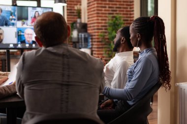 Çeşitli iş adamları uzak girişimcilerle pazarlama istatistiklerini tartışıyor