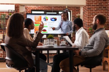 Afrikalı Amerikalı iş kadını monitörün önünde duruyor.