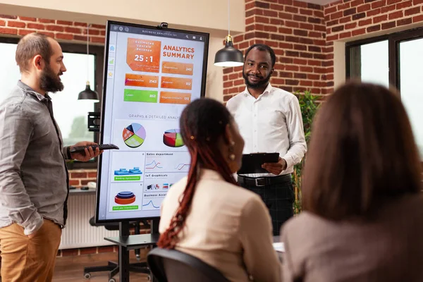 Afrikanischer Unternehmer zeigt Geschäftsdiagramm — Stockfoto