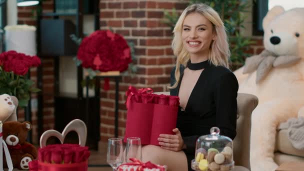 Portrait of elegant blonde woman holding box with beautiful red roses — Stock Video