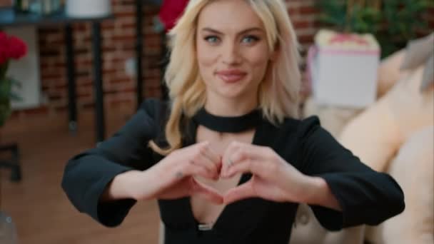 Σέξι ξανθιά γυναίκα δείχνει το σχήμα της καρδιάς σημάδι στην κάμερα — Αρχείο Βίντεο