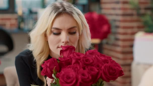 빨간 장미 냄새를 맡고 발렌타인데이를 즐기는 카메라를 보는 매력적 인 여성의 모습 — 비디오