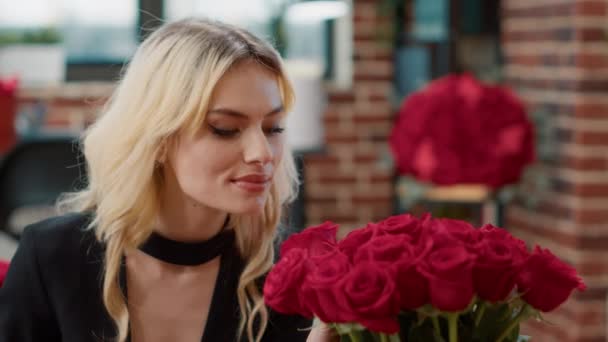 Retrato de romántica mujer hermosa sonriendo y oliendo rosas sintiéndose en amor admirando el ramo de regalo de lujo de rosas — Vídeos de Stock