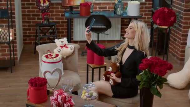 Blond vrouw glimlachen en het nemen van foto met teddybeer cadeau — Stockvideo