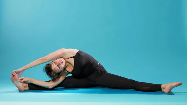 Calma adulto stretching gambe e braccia muscoli sul tappetino — Foto Stock