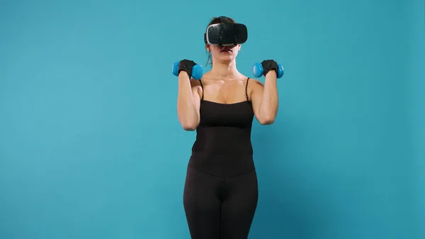 Athlete doing workout training with dumbbells and vr glasses