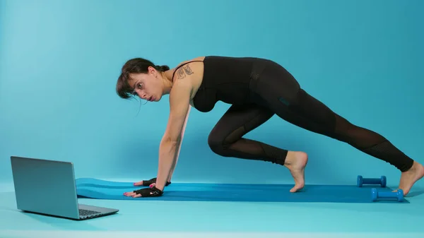 Активна жінка робить фізичні вправи на уроці онлайн-тренувань — стокове фото
