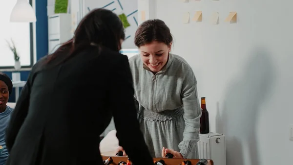 Women having fun while playing with foosball table at office — Stock Photo, Image