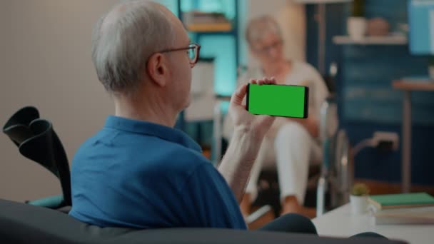 Yaşlı adam cep telefonunda yatay yeşil ekran kullanıyor