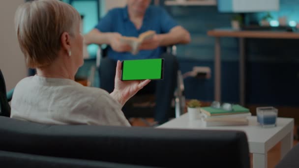 Mujer mayor sosteniendo la pantalla verde horizontal en el teléfono inteligente — Vídeos de Stock