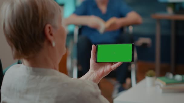 Pensionato femminile guardando schermo verde orizzontale sul telefono cellulare — Video Stock