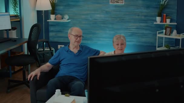 Elder couple watching movie on tv to enjoy retirement in living room — Stock Video