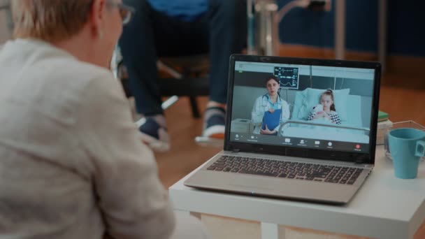 Emerytowany dorosły przy użyciu wideokonferencji na laptopie do udziału w spotkaniu online — Wideo stockowe