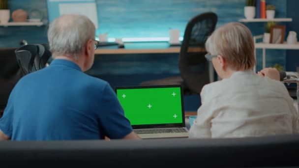 Старшая пара с ноутбуком с зеленым экраном в гостиной — стоковое видео