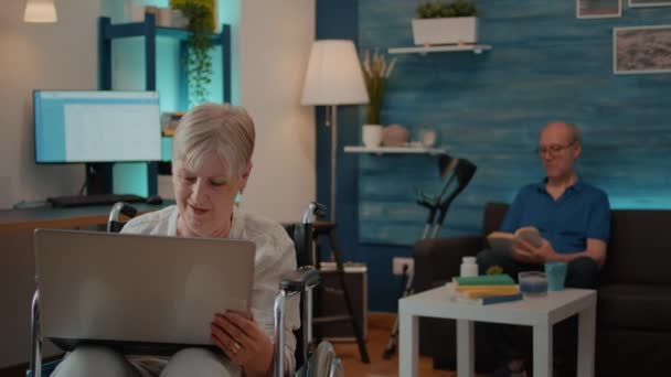 Wanita senior dengan cacat fisik melihat layar laptop — Stok Video