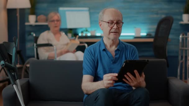 Osoba v důchodu držící digitální tablet mluvit o videohovoru — Stock video