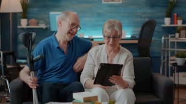 Online video çağrısında tablet webcam 'e el sallayan yaşlı çift