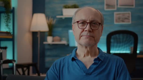 Porträt eines älteren Menschen, der lächelt und den Ruhestand zu Hause genießt — Stockvideo