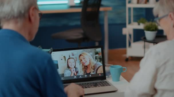 Бабушка и дедушка используют онлайн конференцию на ноутбуке — стоковое видео