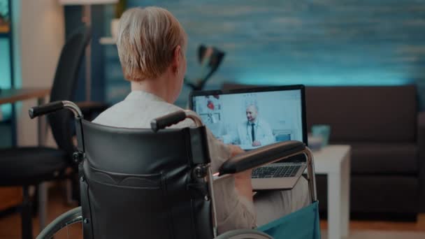 Rentner im Rollstuhl telefoniert per Videokonferenz — Stockvideo