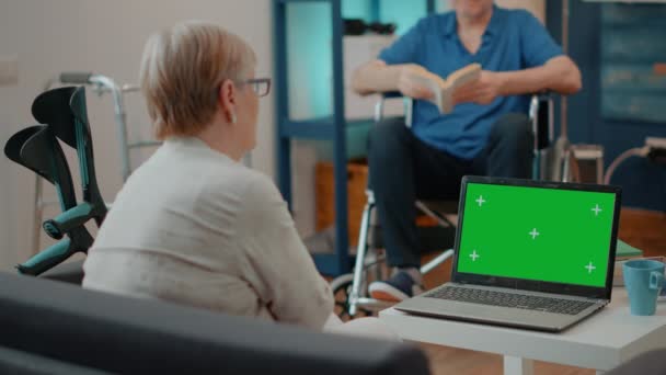 Persona jubilada con muletas mirando a la computadora portátil con pantalla verde — Vídeos de Stock