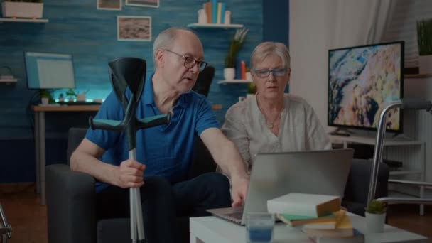 Vieilles personnes handicapées naviguant sur Internet sur ordinateur portable — Video