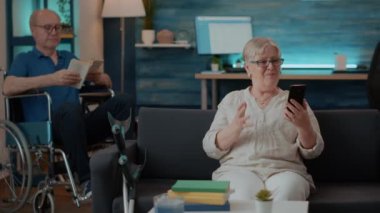 Son sınıf öğrencisi telekonferansta konuşmak için akıllı telefon tutuyor.