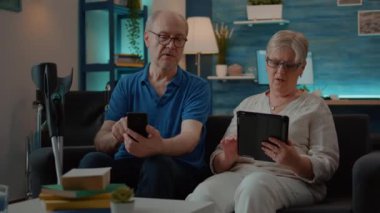 Büyükbabalar evde akıllı telefon ve dijital tablet kullanıyorlar.