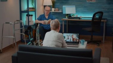 Laptop 'ta uzaktan video konferansı kullanan yaşlı kadın