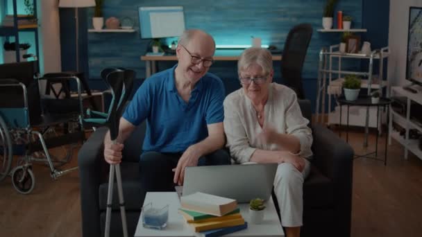 Oudere mensen die laptop gebruiken om met familie te praten op een videoconferentie op afstand — Stockvideo