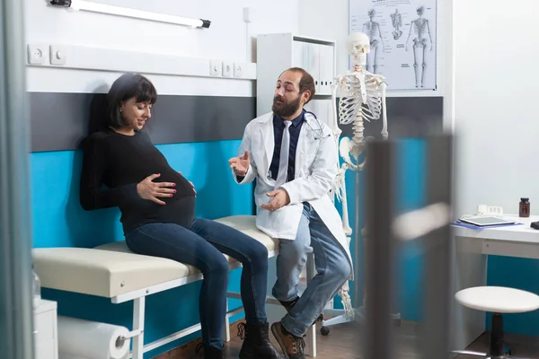 Paciente grávida que frequenta consulta médica com médico — Fotografia de Stock