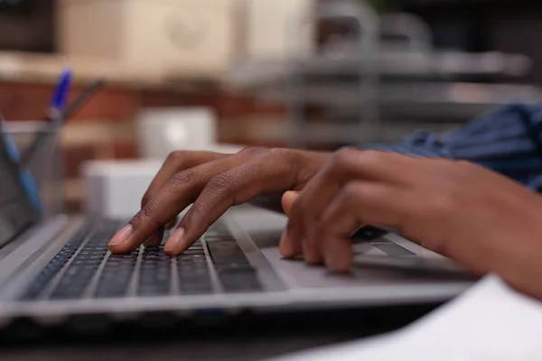 Closeup of african american hands typing business data on portable computer keyboard — Stock Photo, Image